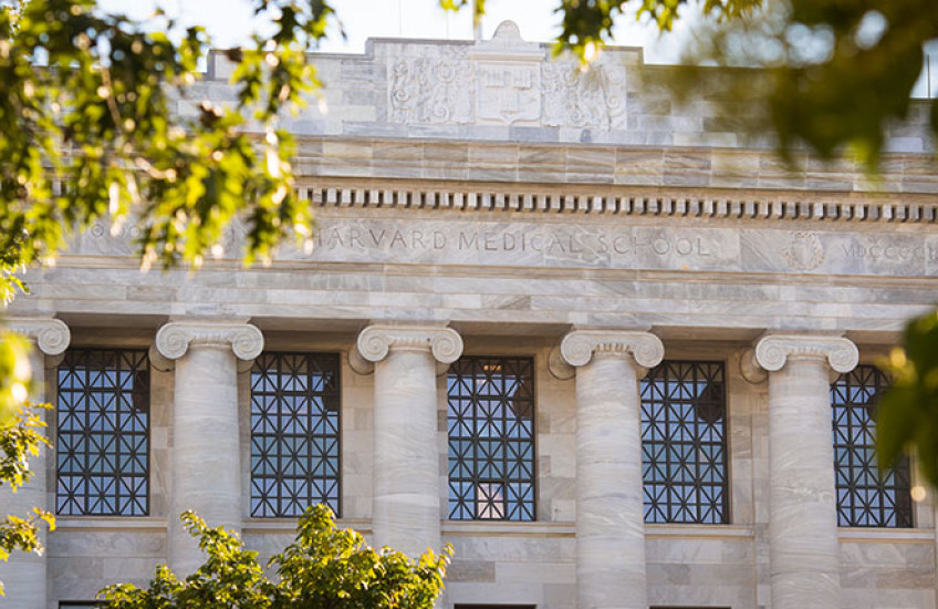 Photo of Gordon Hall on the HMS campus, framed by trees