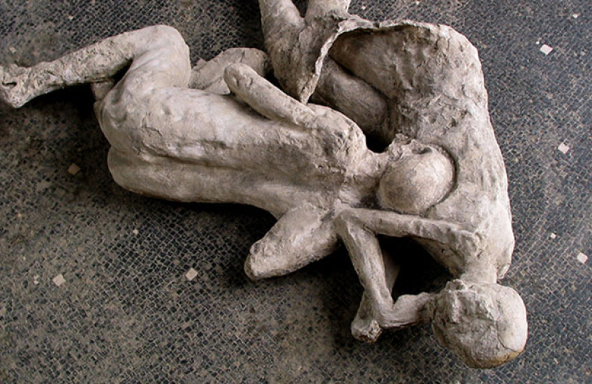 Plaster casts of two figures entangled on a tile floor
