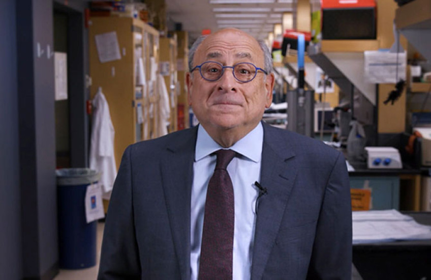 Stuart Orkin, standing in a laboratory wearing a suit, looks into the camera with a slight smile