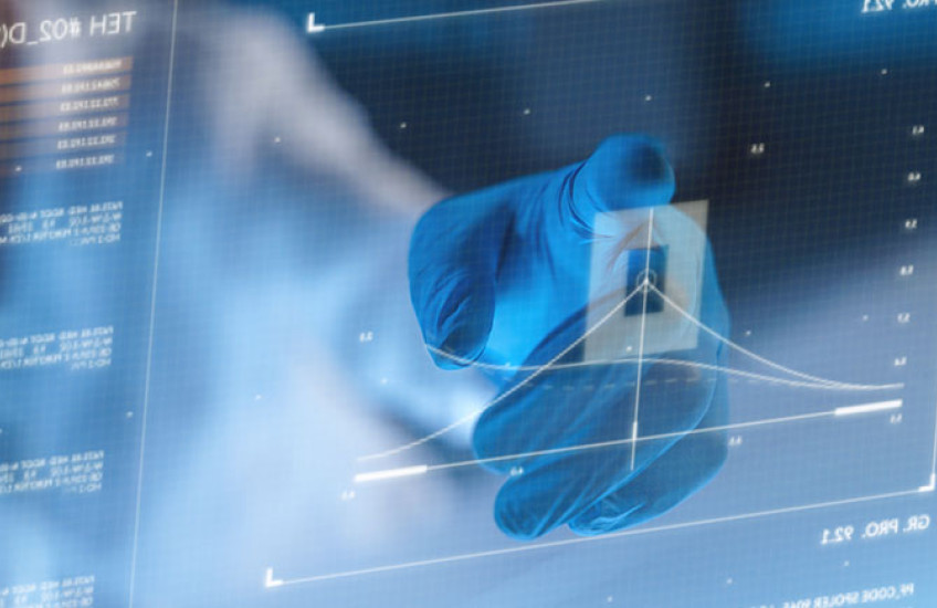 A hand in a protective glove, using a futuristic screen to look at a diagram