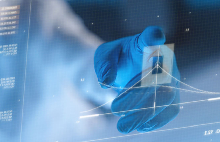 A hand in a protective glove, using a futuristic screen to look at a diagram