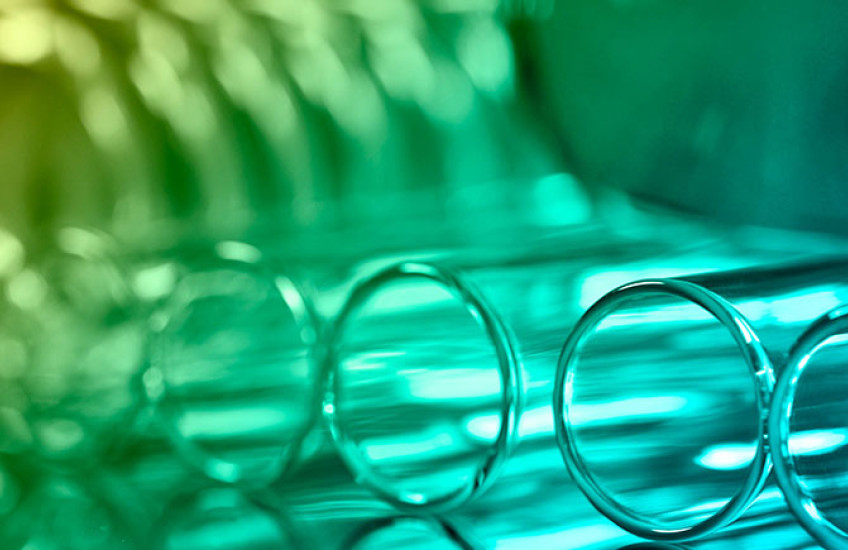 a closeup of test tubes lying on a table lit in green light