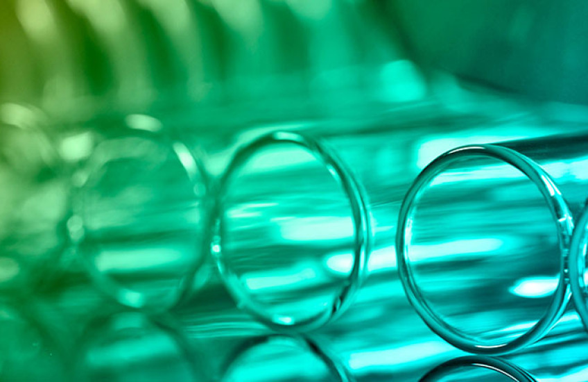 a closeup of test tubes lying on a table lit in green light