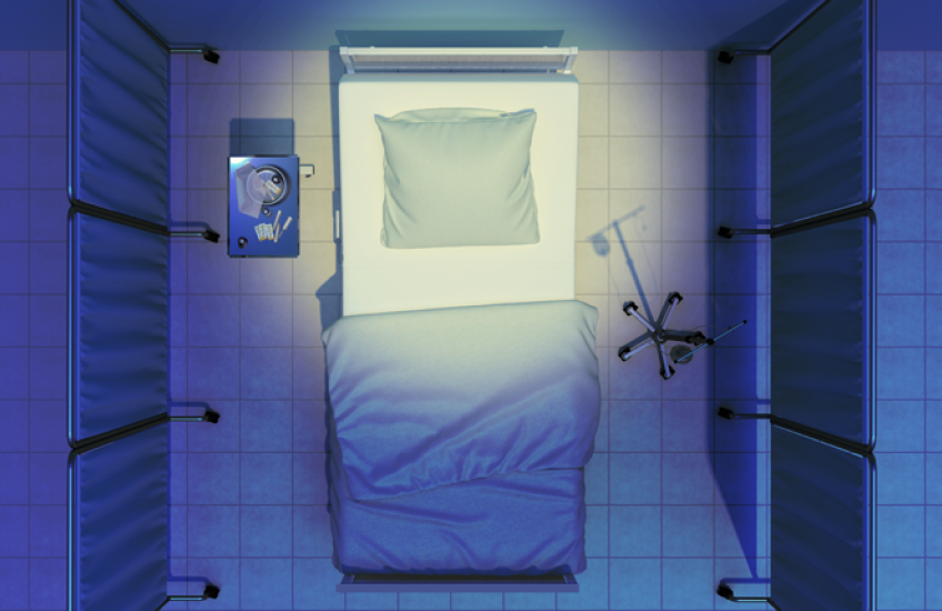 Overhead view of an empty hospital bed with blue sheets, surrounded by privacy screens, with an IV stand on one side and a small table with supplies on the other.
