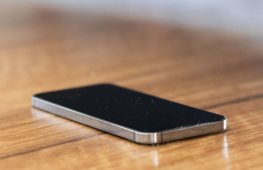 A phone with screen off sitting on a table