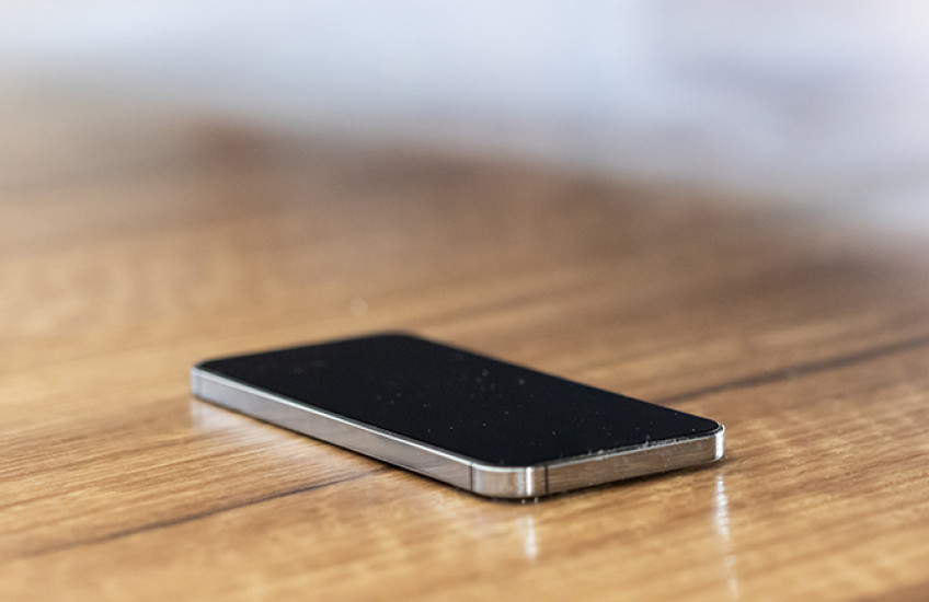 A phone with screen off sitting on a table
