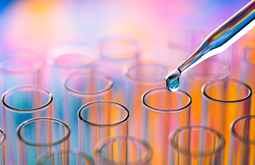 Close-up of pipette dripping chemical in a test tube
