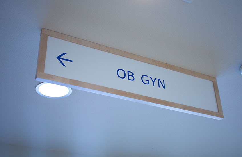 A hospital sign that reads "OB GYN" with an arrow pointing to the left