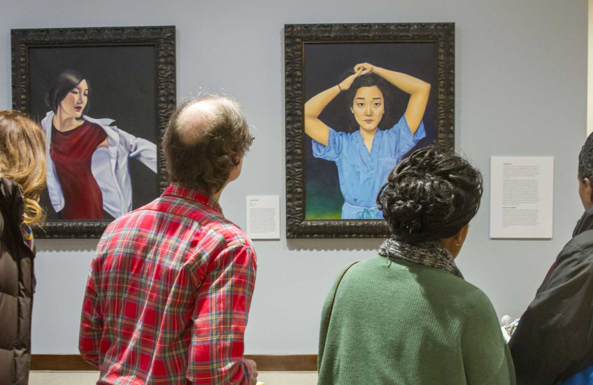 Visitors viewing the Chen paintings in the HMS dean's office.
