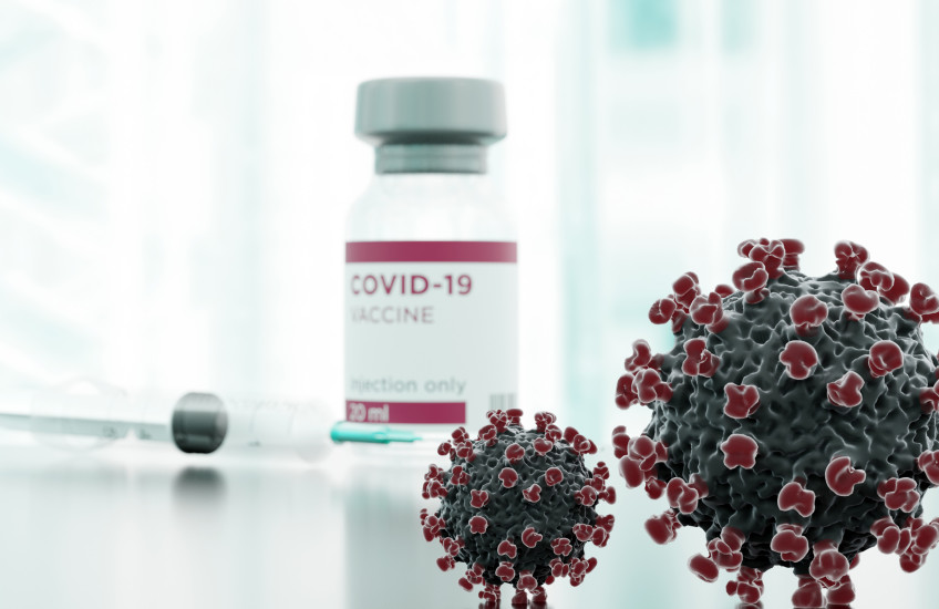 Clinical image showing syringe, vaccine vial, and stylized covid spike proteins