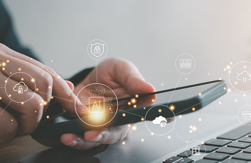 photo of a user looking at a smartphone screen in front of a computer