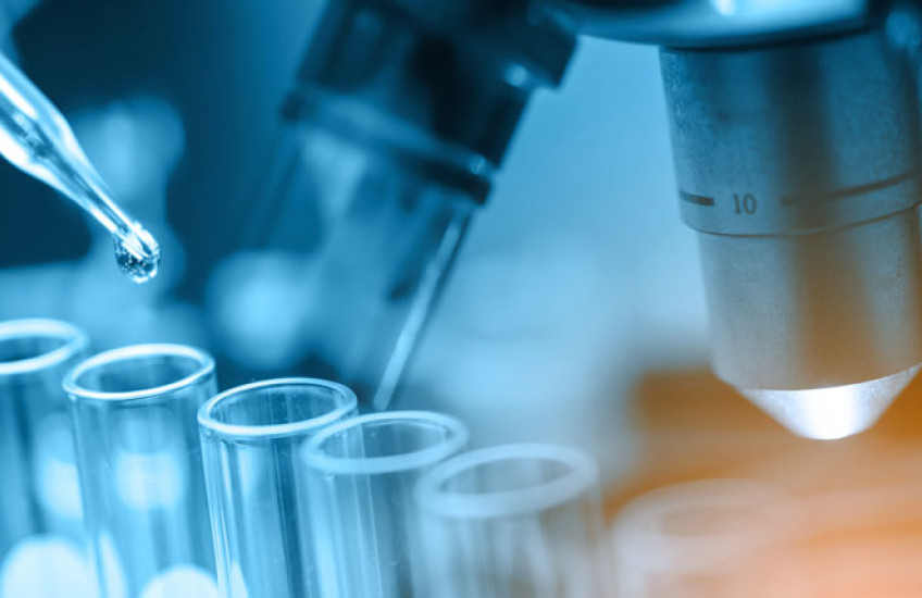 Photo illustration of a pipette, some test tubes and a microscope