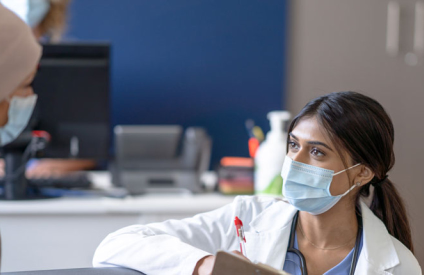 Photo of a health care provider interviewing a female patient 