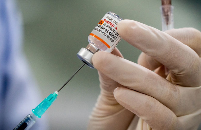 gloved hand with syringe and covid treatment 