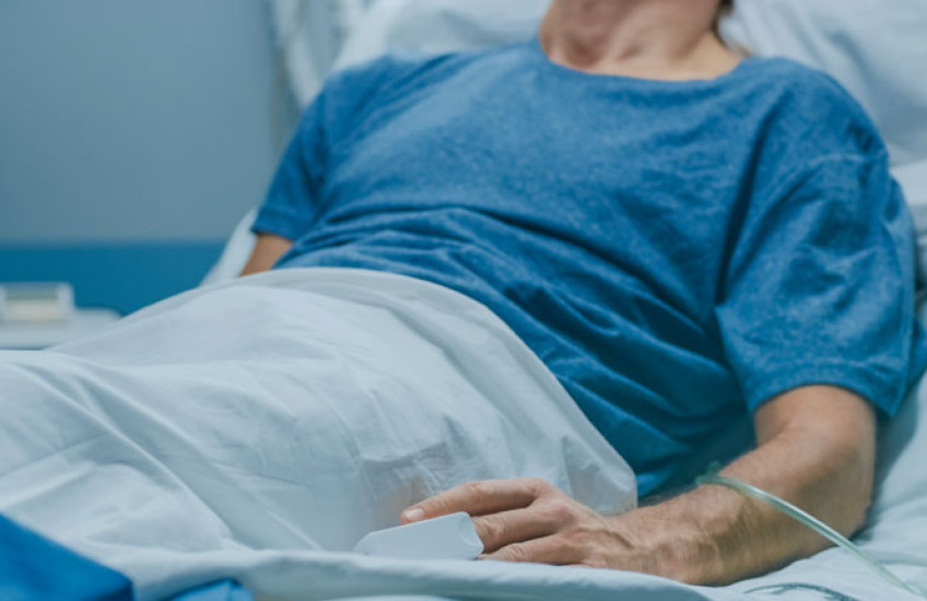 The torso of a patient lying in a hospital bed