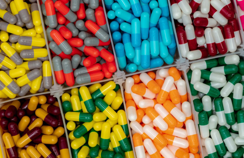 Multiple rectangular compartments filled with large, multi-colored pills
