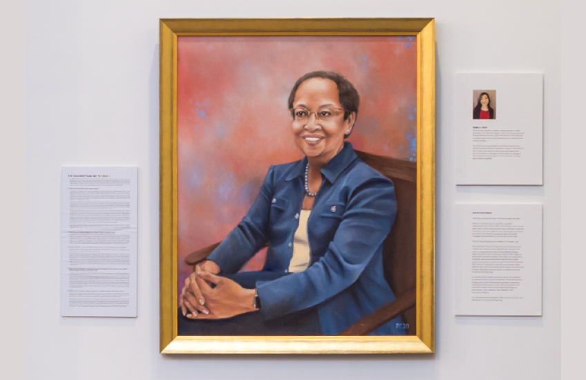 Oil painting of Higginbotham flanked by placards with the artist's bio, Q&A with her, and info about the artwork