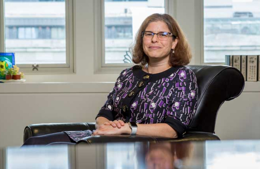 Rosalind Segal seated at her desk in her TMEC building office.