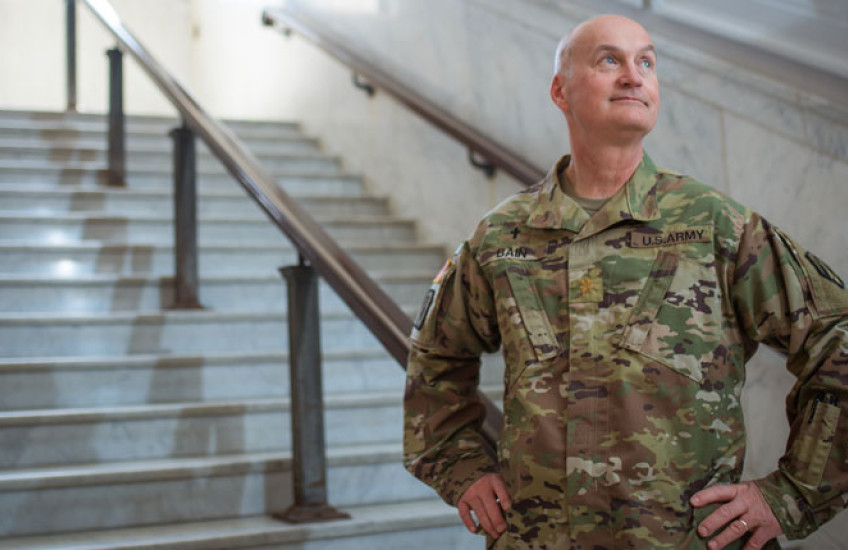 Bain wearing military uniform standing on marble steps with hands on hips
