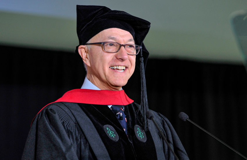 Daley in regalia speaking into microphone