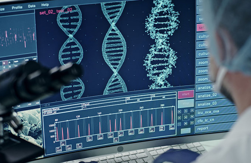 A scientist looks at computer screen showing a DNA sequence