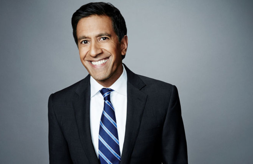 Man in a blue suit and stripe tie smiling