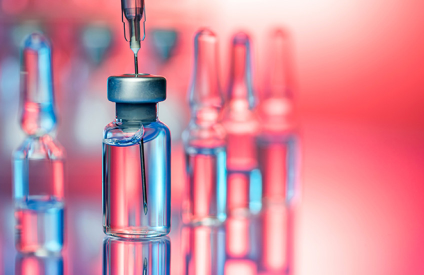 Stylized photograph of unlabeled bottles of vaccine