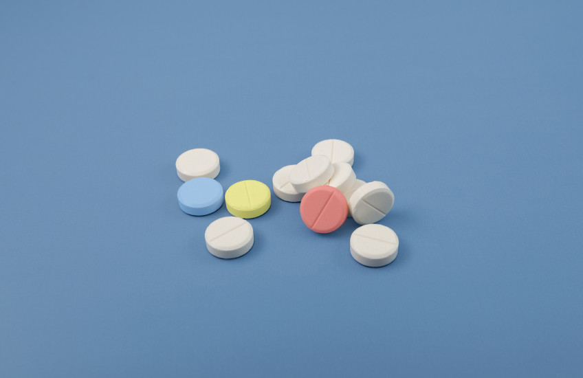 Photo of multicolored pills on a blue background