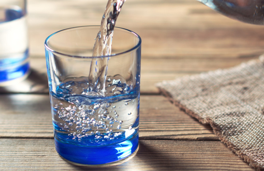 Photo of water being poured from a pitcher into a glass