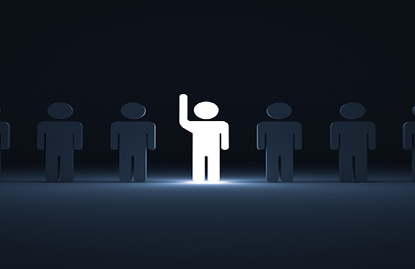 Image of One glowing light man raising his hand among other dim people in the row on dark blue background with shadows