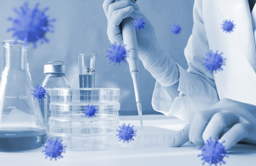 Photoillustration of coronavirus floating around lab equipment with person holding a pipette