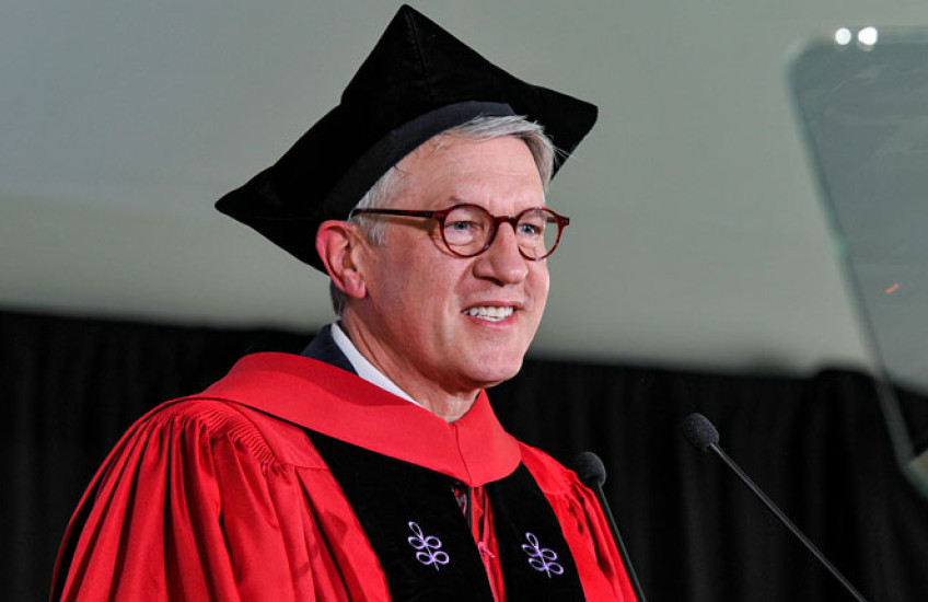 Giannobile wearing regalia speaking into microphone