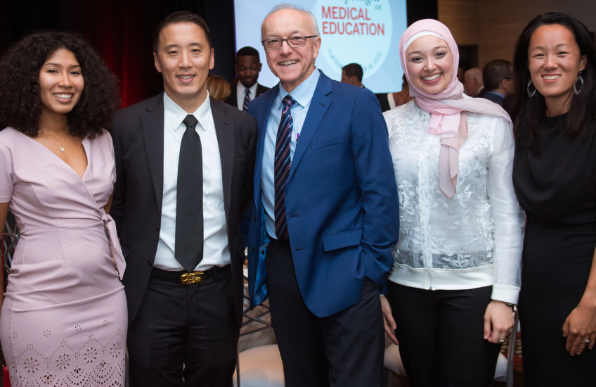 Photo of 4 students and former student with Dean Daley, all smiling at the camera
