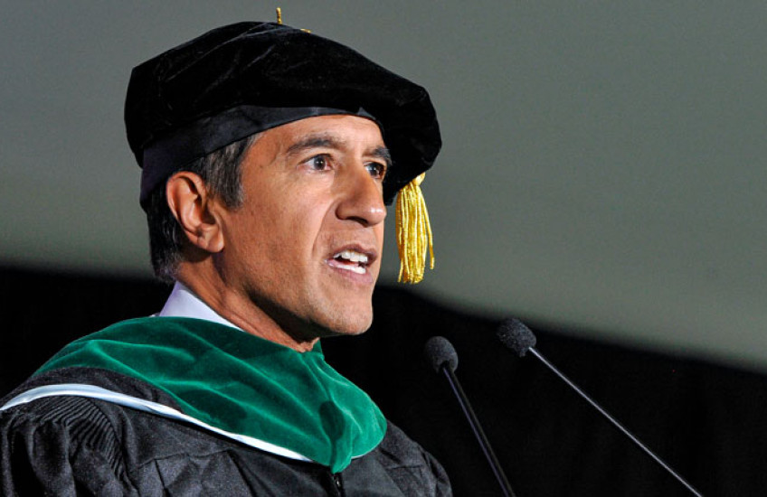 Gupta in regalia speaking into microphone