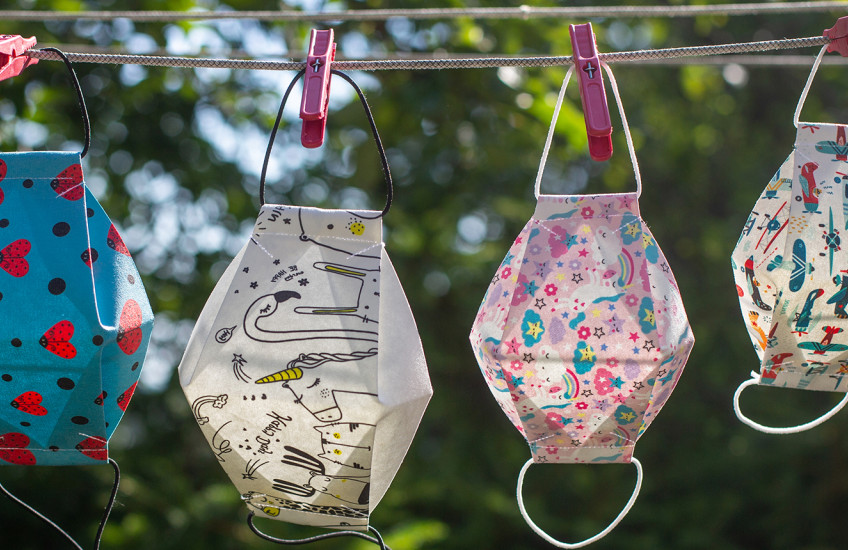 Diverse, colorful masks hang on a laundry line.