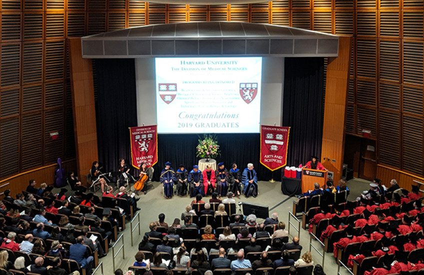 Auditorium with banners, program heads, graduates and guests