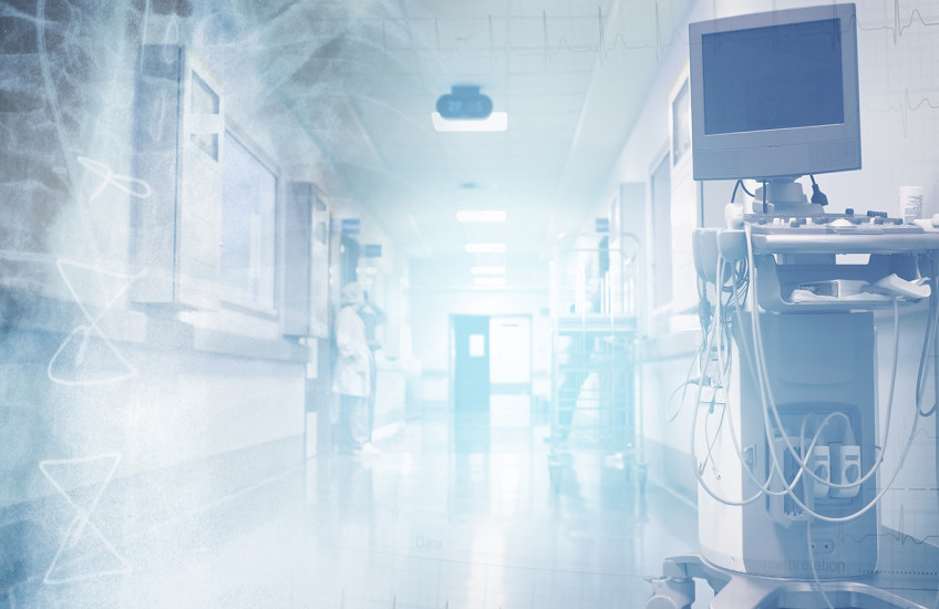 Translucent images of ECG chart and a chest x-ray image superimposed on a brightly lit hospital corridor