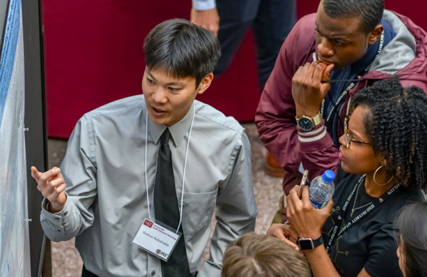 HMS student explaining his research project to other students at the forum 