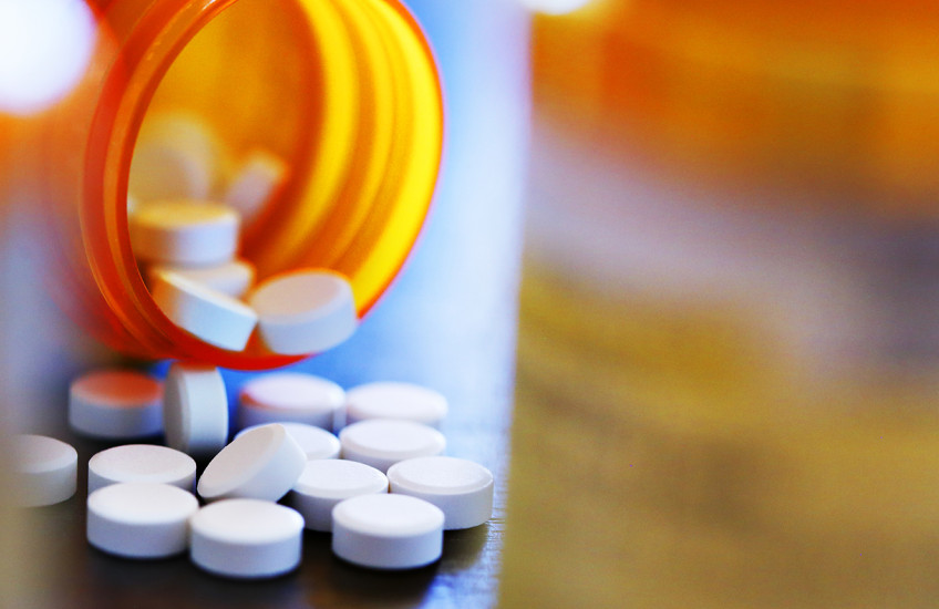 A bottle of pills spilling on a table