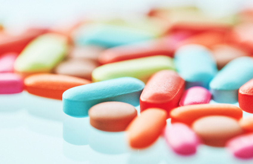 Colorful pills on a reflective surface