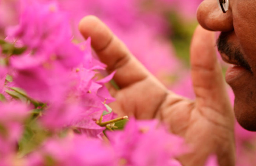 man smelling flowers