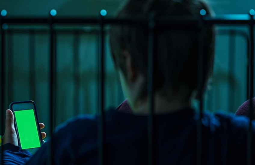 Teen looking at screen in bed at night