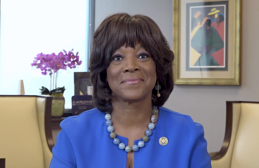 Image of Dr. Rice, wearing a blue suit, seated at a desk in her office