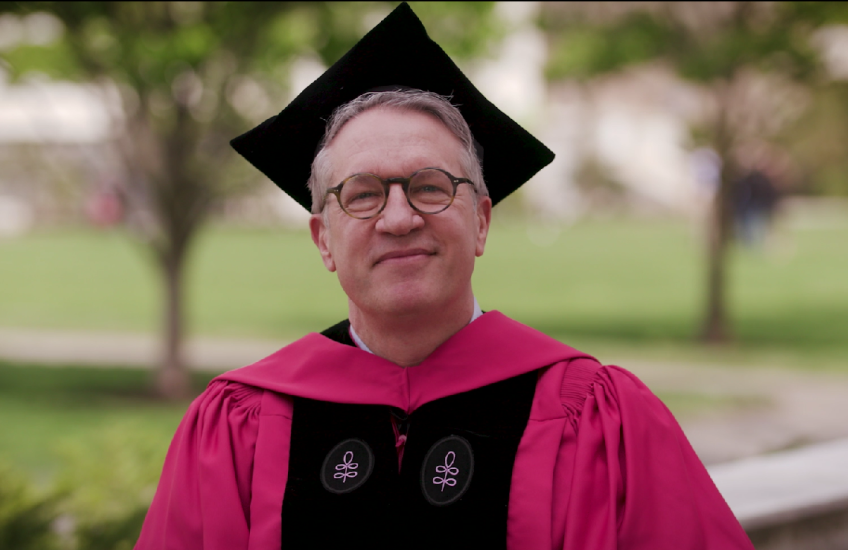 Dr. Giannobile, dressed in academic regalia, speaking outdoors