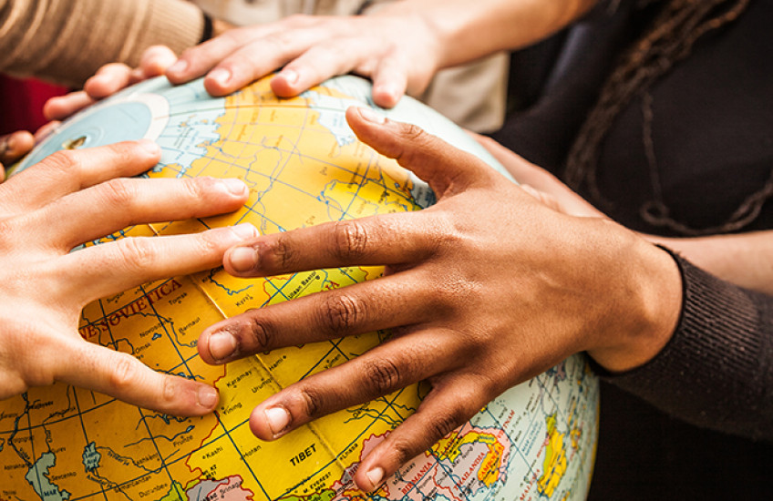 multiethnic hands on a globe