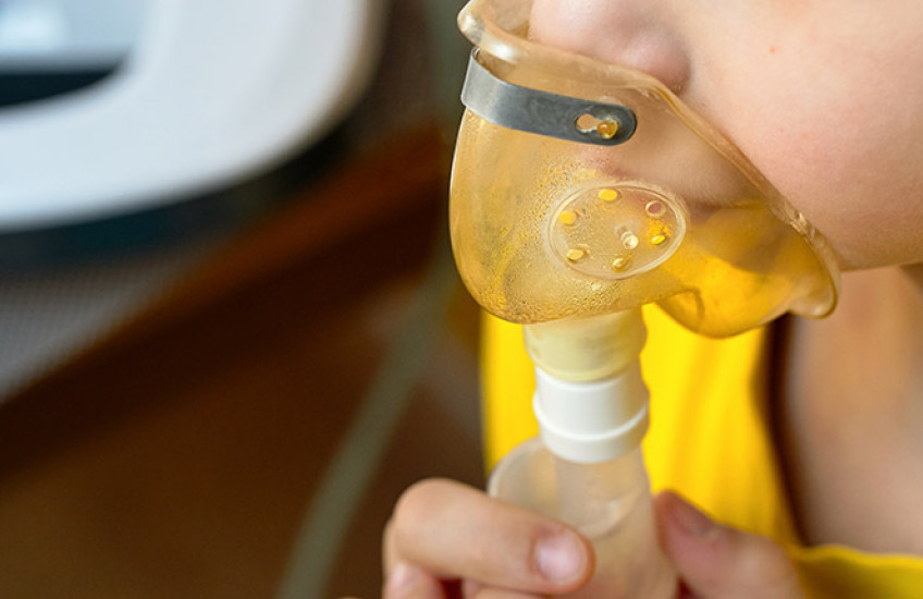 close up of child's face making an inhalation with a nebulizer