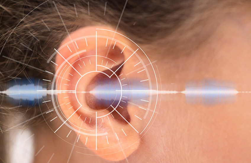 Close up of a white child's ear with a sound wave overlaid digitally