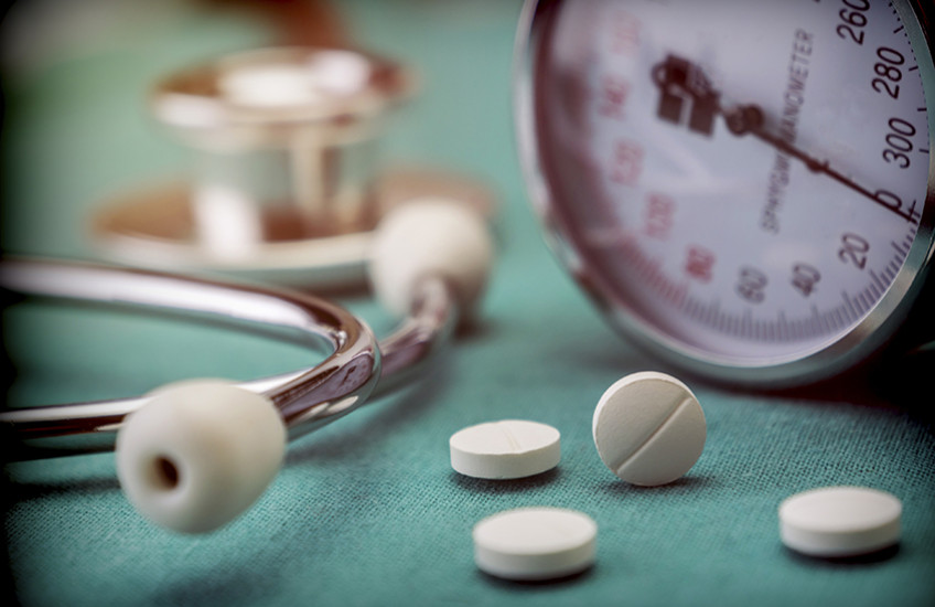 stock image of blood pressure cuff and pills with stethoscope