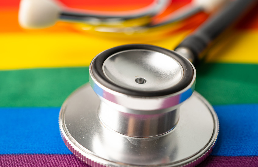 A stethoscope rests on a table covered with  rainbow-colored cloth.
