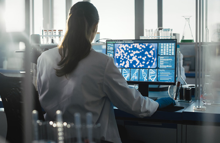 A person sits at a computer in a laboratory 